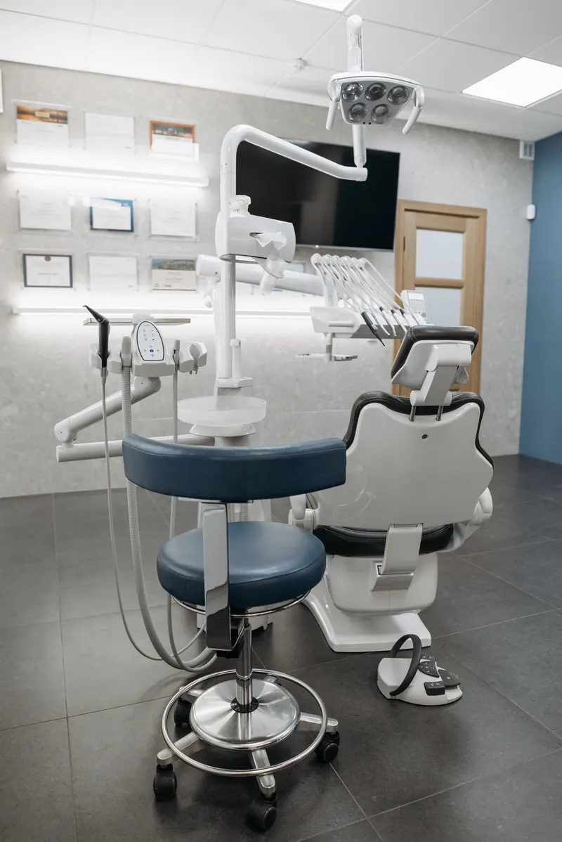 Consultório odontológico moderno com cadeira azul e equipamentos
